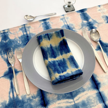 Rose pink linen table runner dyed with indigo in Pleat pattern, shown here with gold napkin.