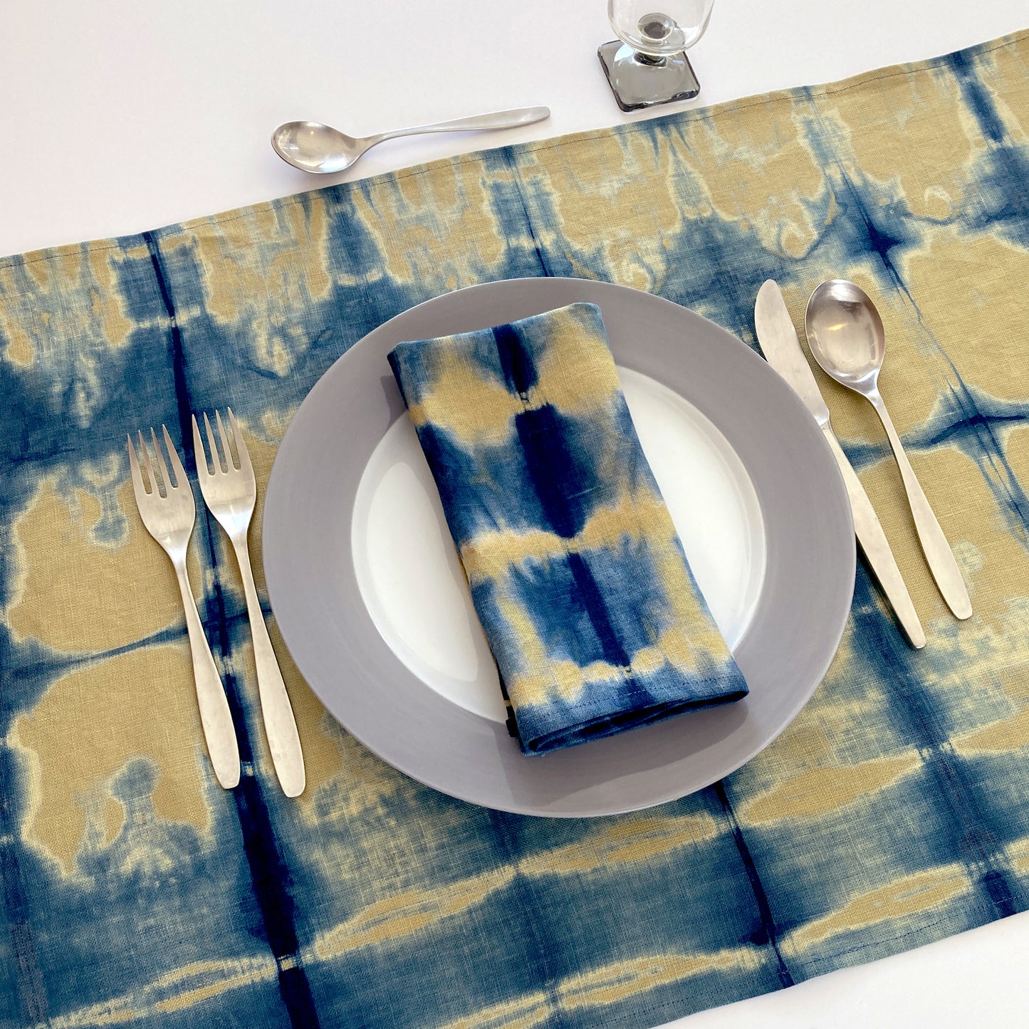 Gold mustard linen table runner dyed with indigo in Pleat pattern, shown here with matching napkin.