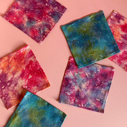 A grouping of hand dyed cocktail napkins in pink, purple, indigo, turquoise and orange.