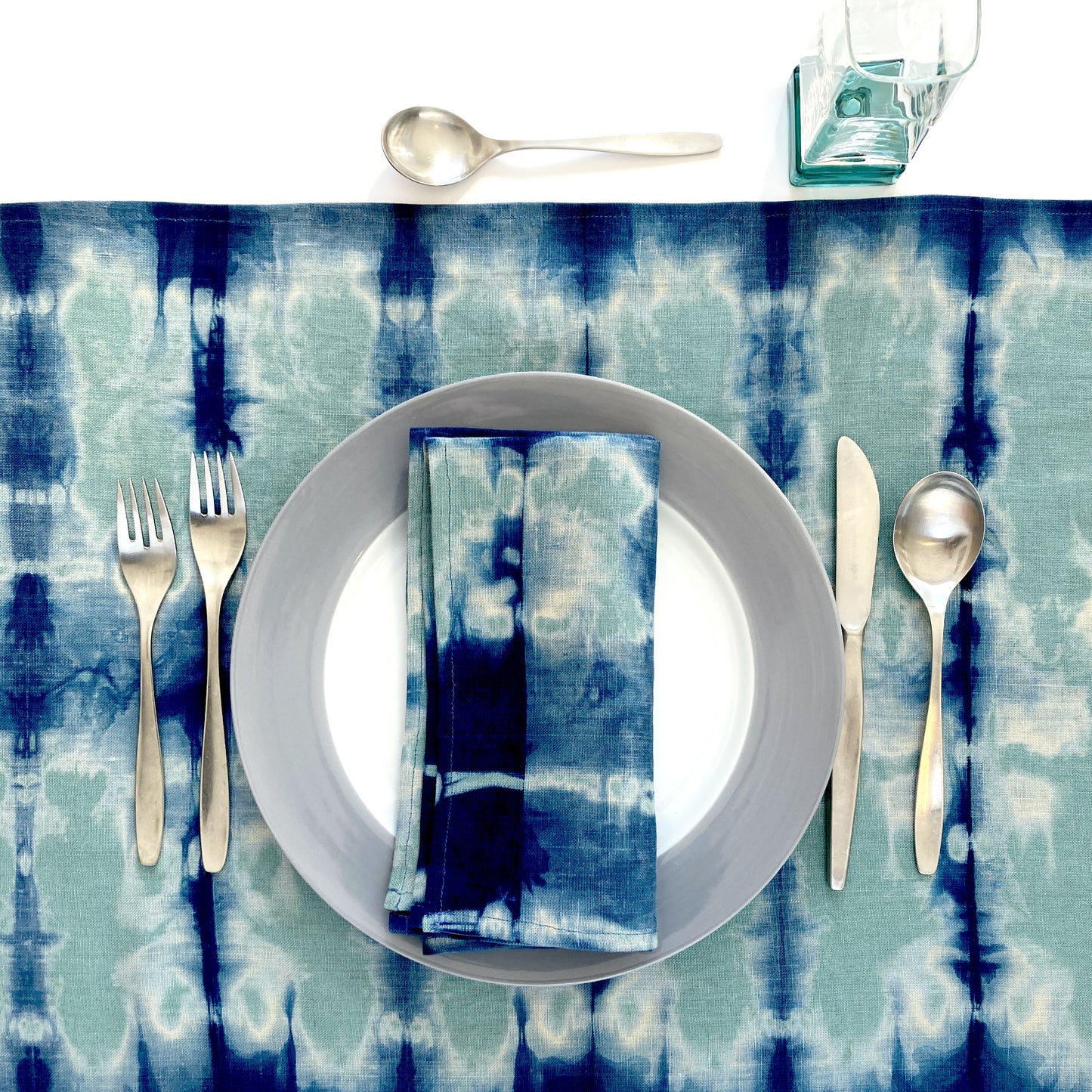 Jade green linen table runner dyed with indigo in Pleat pattern, shown here with matching napkin.