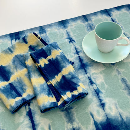 Jade green linen table runner dyed with indigo in Pleat pattern, shown here with napkins in gold.