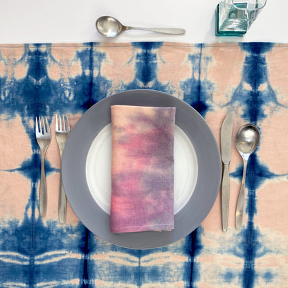 Rose pink linen table runner dyed with indigo in Pleat pattern, shown here with hand painted napkin.