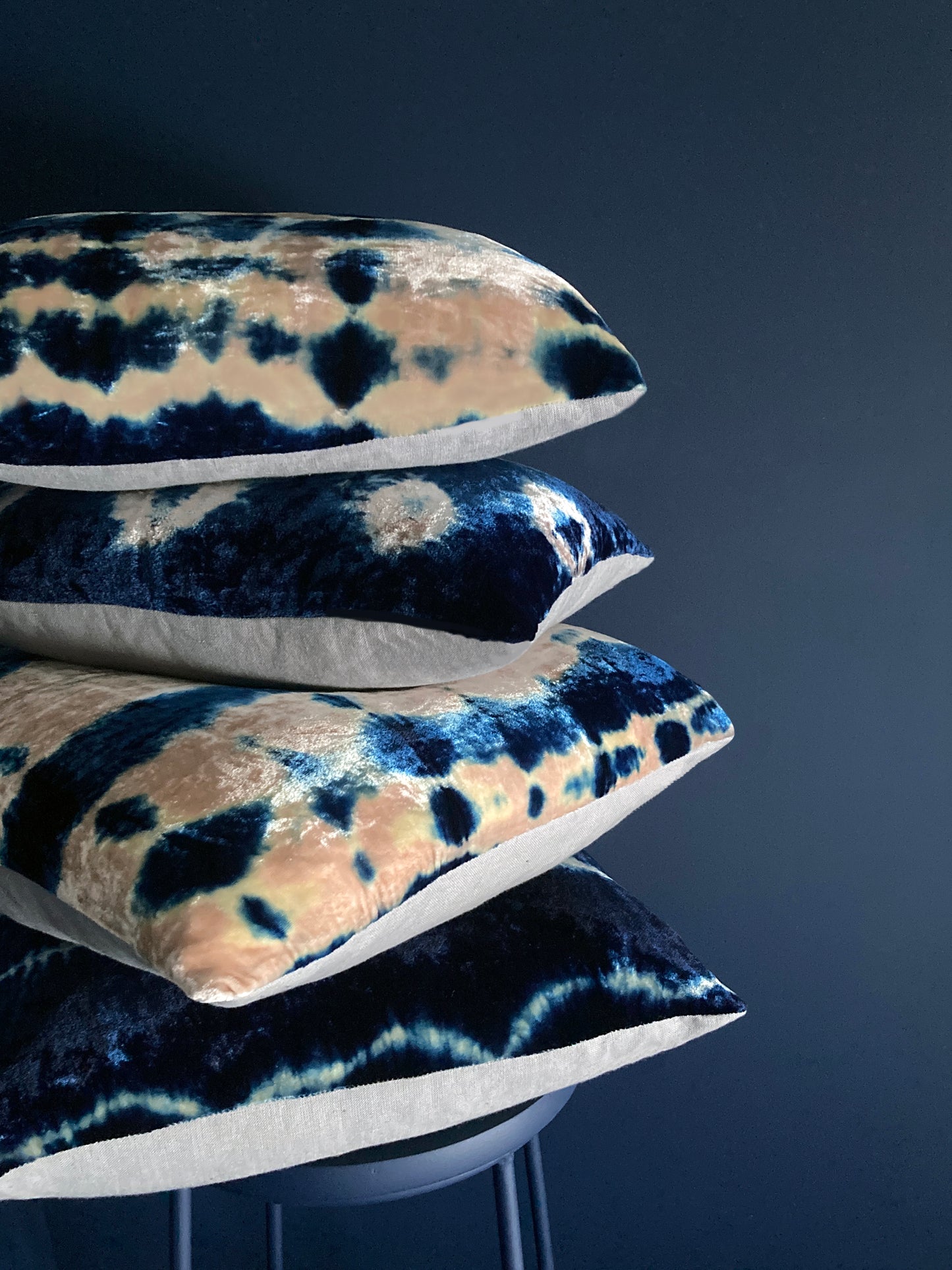 Grouping of rose and indigo velvet pillows in abstract patterns.