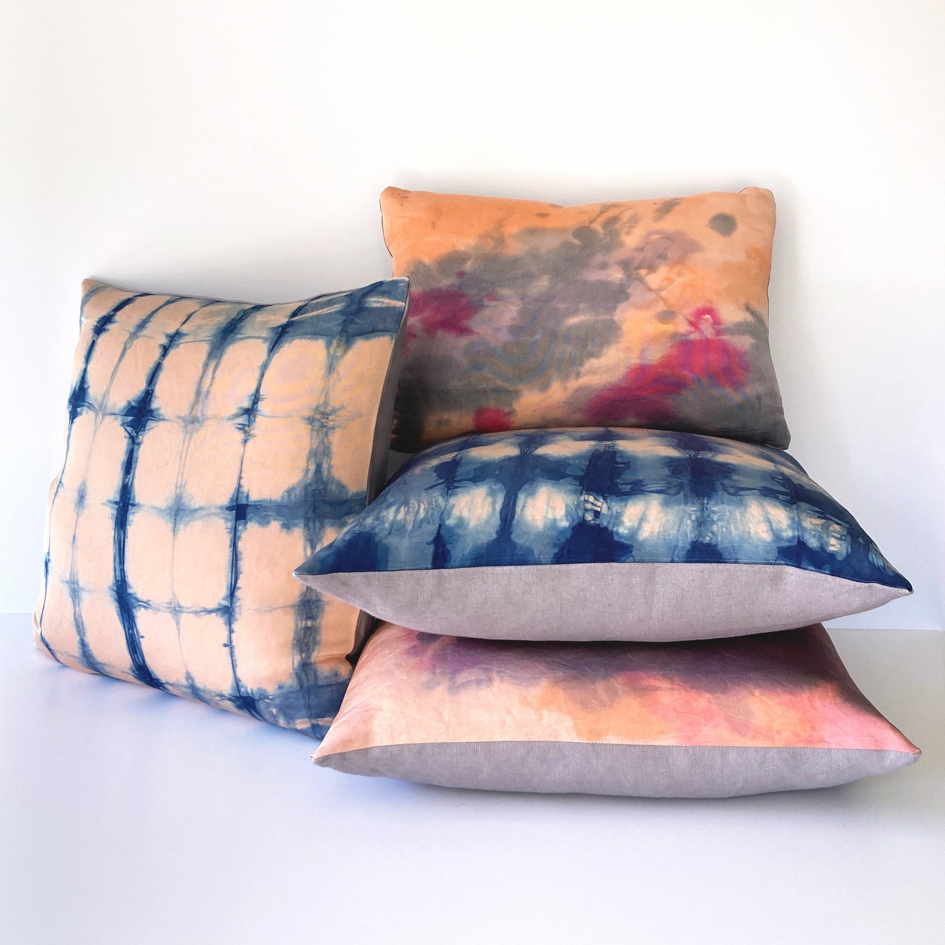 Grouping of rose pink silk pillows in abstract patterns.