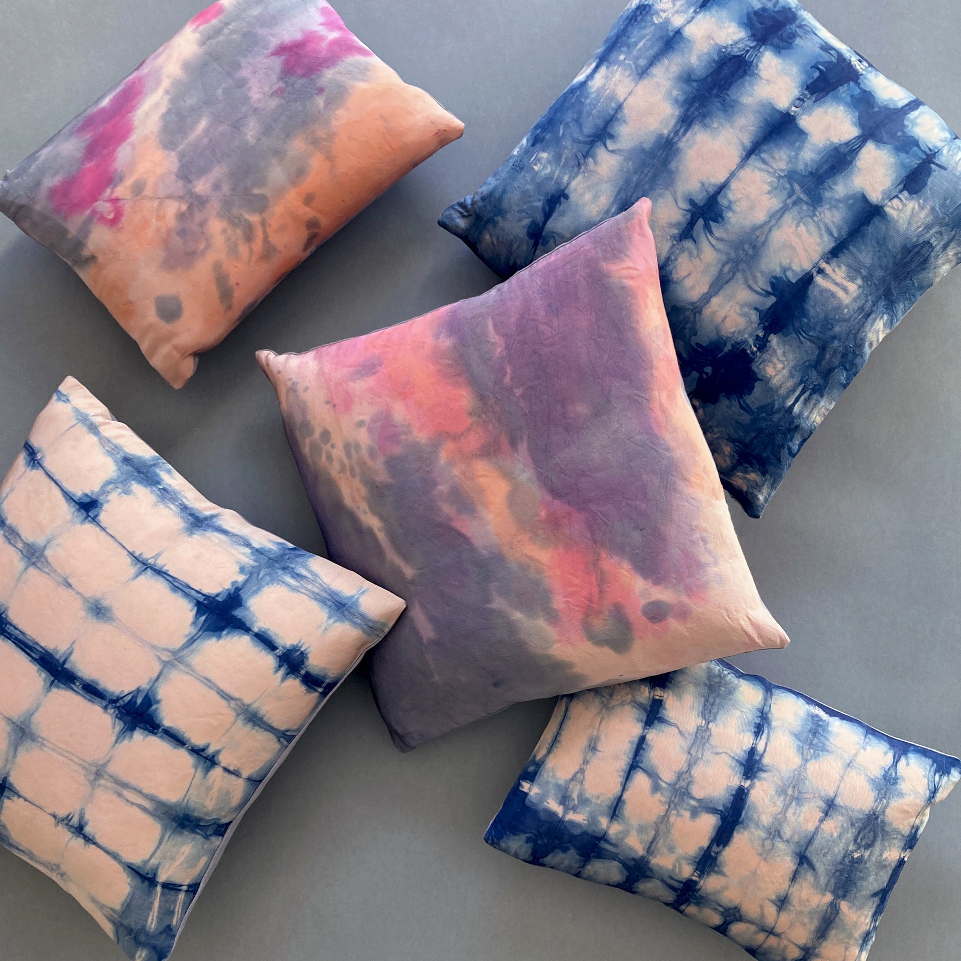 Grouping of rose pink silk pillows in abstract patterns.