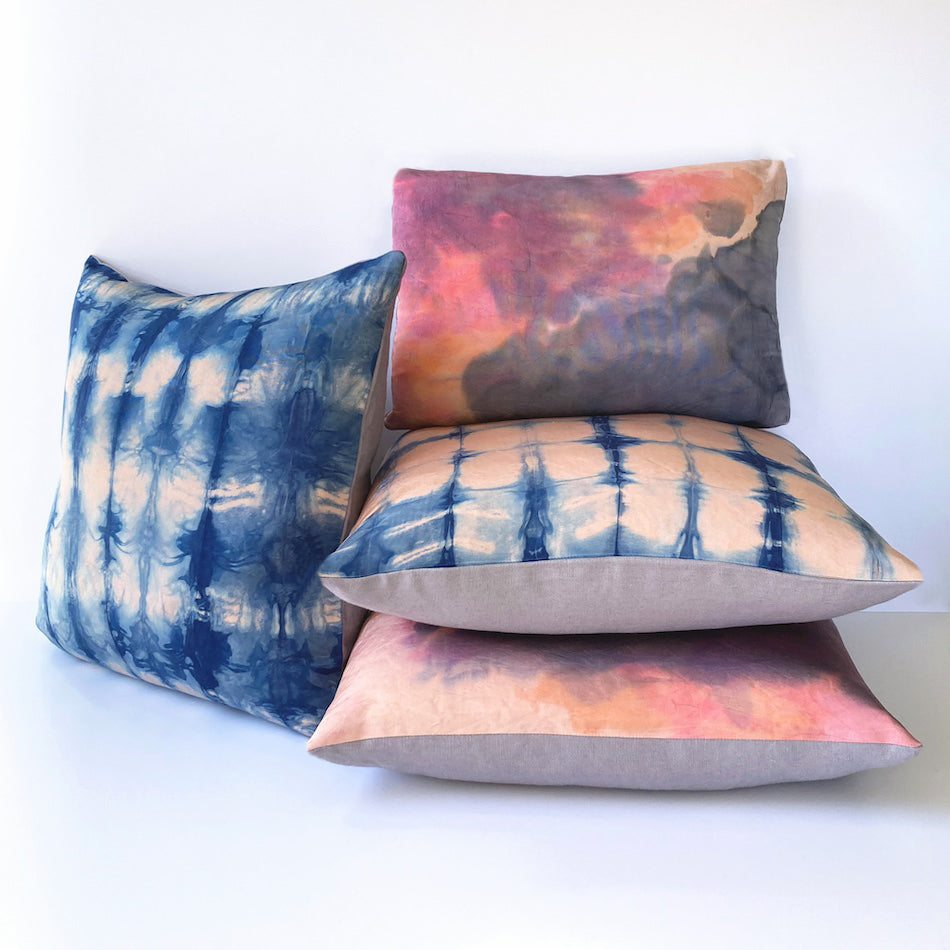 Grouping of rose pink silk pillows in abstract patterns.