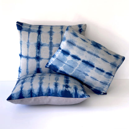 Grouping of silver gray silk pillows in abstract patterns.