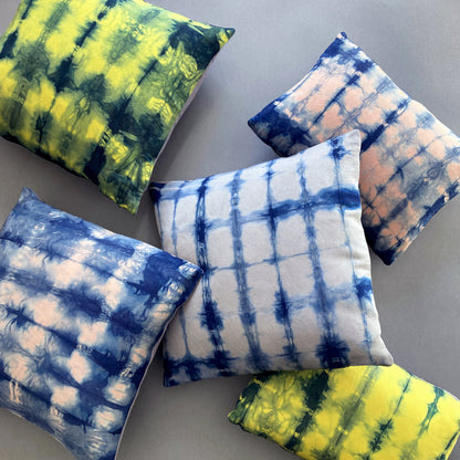 Canary yellow, pink and gray silk pillows dyed with indigo, in abstract patterns.