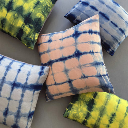 Canary yellow, pink and gray silk pillows dyed with indigo, in abstract patterns.