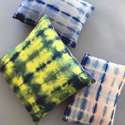 Canary yellow, pink and gray silk pillows dyed with indigo, in abstract patterns.