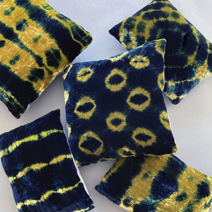 Grouping of gold and indigo velvet pillows in abstract patterns.