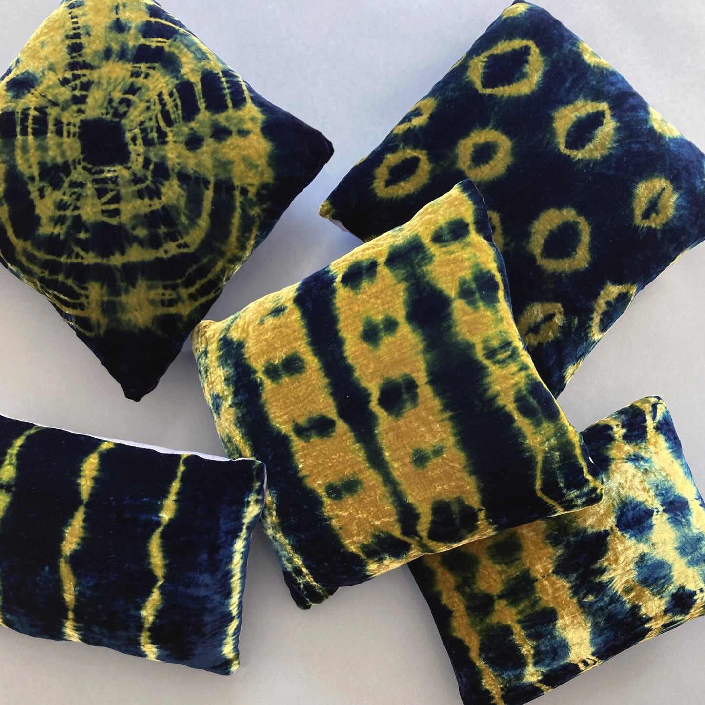 Grouping of gold and indigo velvet pillows in abstract patterns.