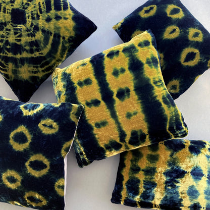 Grouping of gold and indigo velvet pillows in abstract patterns.