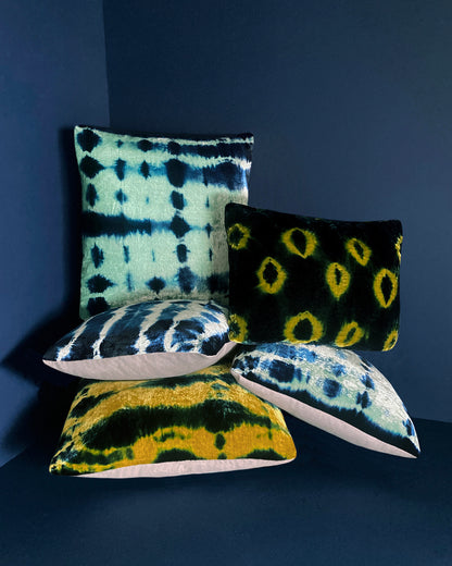 Grouping of gold, jade and indigo velvet pillows in abstract patterns.