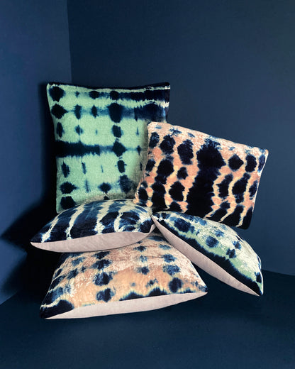 Grouping of jade, pink and indigo velvet pillows in abstract patterns.