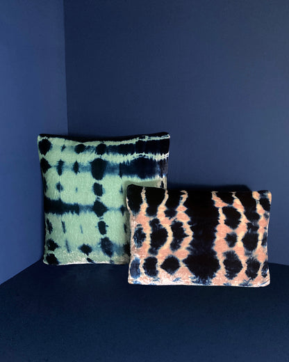 Grouping of jade, pink and indigo velvet pillows in abstract patterns.