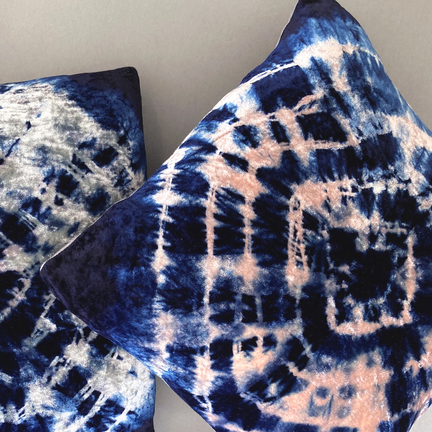 Grouping of silver, pink and indigo velvet pillows in abstract patterns.