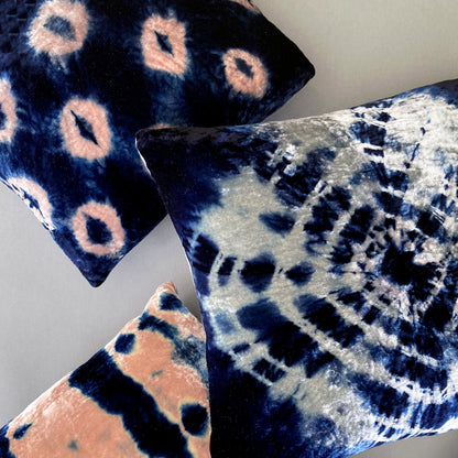 Grouping of rose, silver and indigo velvet pillows in abstract patterns.