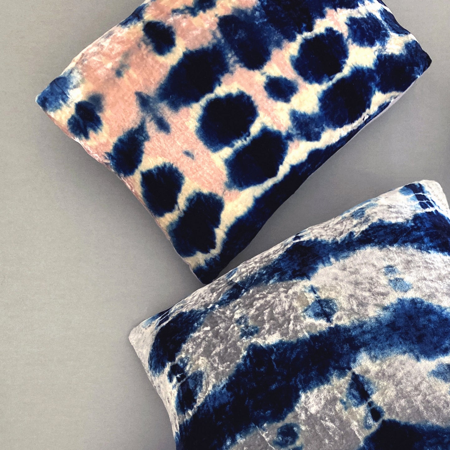 Grouping of rose, silver and indigo velvet pillows in abstract patterns.