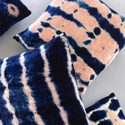 Grouping of rose and indigo velvet pillows in abstract patterns.