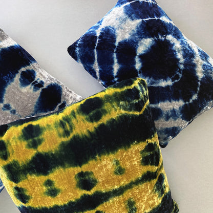 Grouping of gold, silver and indigo velvet pillows in abstract patterns.