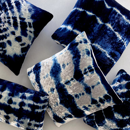 Grouping of silver and indigo velvet pillows in abstract patterns.