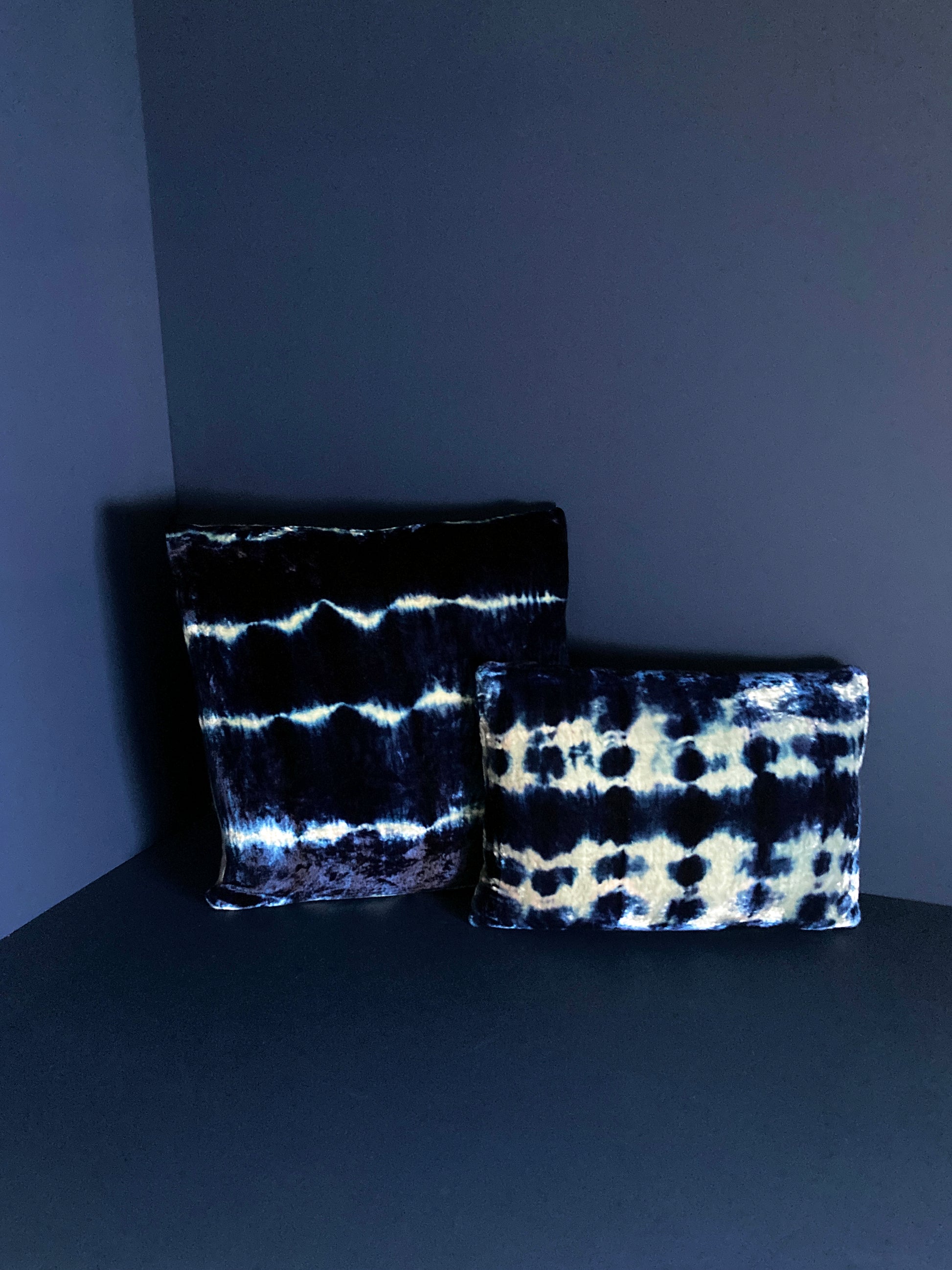 Grouping of silver and indigo velvet pillows in abstract patterns.